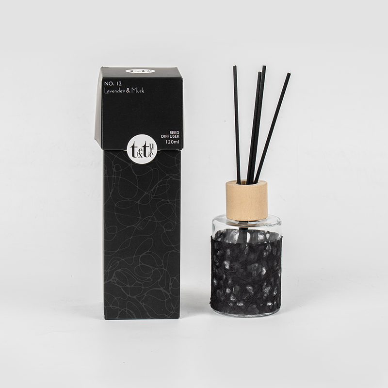 Classica bottiglia rotonda in vetro con coperchio in legno in un simpatico diffusore a bastoncino decorativo in carta-venditore di fragranze per la casa