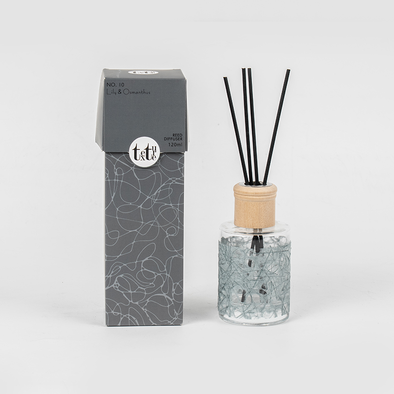 Classica bottiglia rotonda in vetro con coperchio in legno in un simpatico diffusore a bastoncino decorativo in carta-venditore di fragranze per la casa