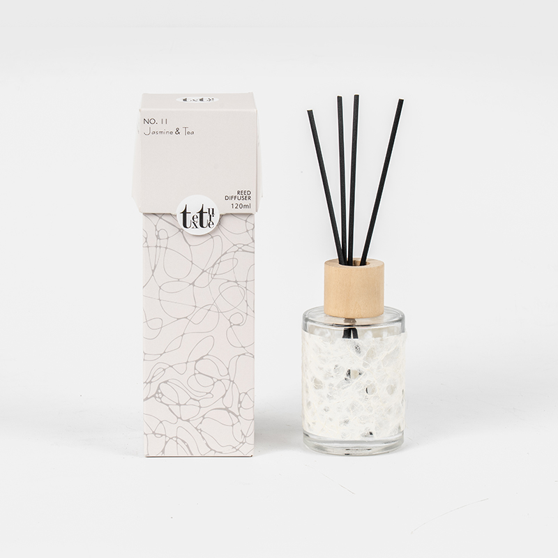 Classica bottiglia rotonda in vetro con coperchio in legno in un simpatico diffusore a bastoncino decorativo in carta-venditore di fragranze per la casa